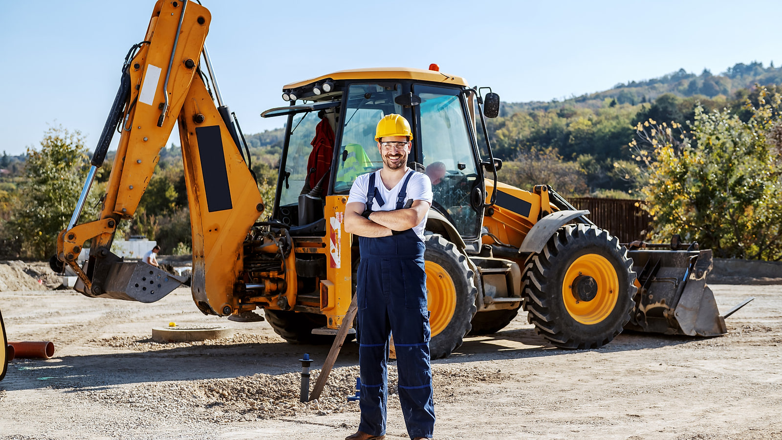 Conducteur de mini-pelle montrant sa carte CACES et son AIPR au chef de chantier près d'une tranchée