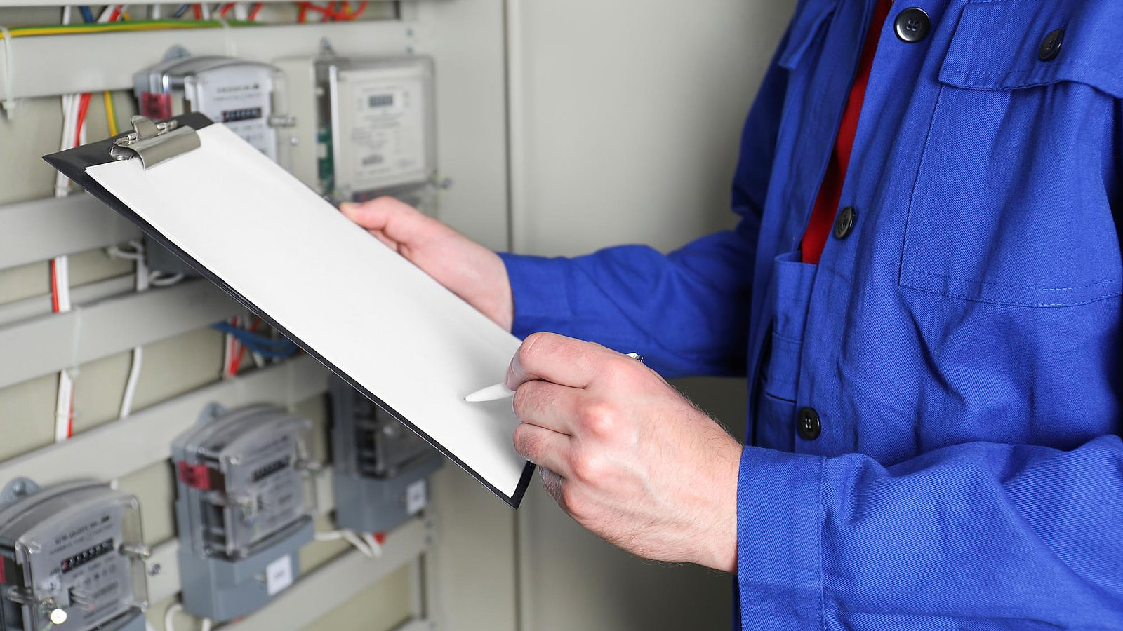 Électricien habilité posant un cadenas de condamnation sur le sectionneur d'une armoire électrique