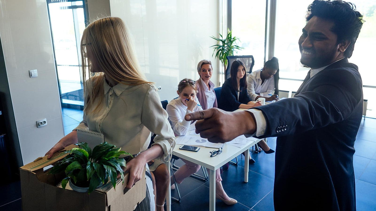 Responsable RH et cariste examinant un plan de reconversion professionnelle devant les rayonnages d'un entrepôt