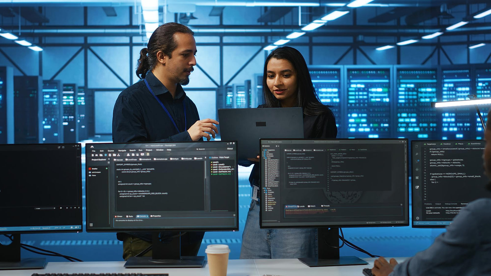Technicien habilite relevant des parametres devant une armoire TGBT dans une salle serveurs de data center