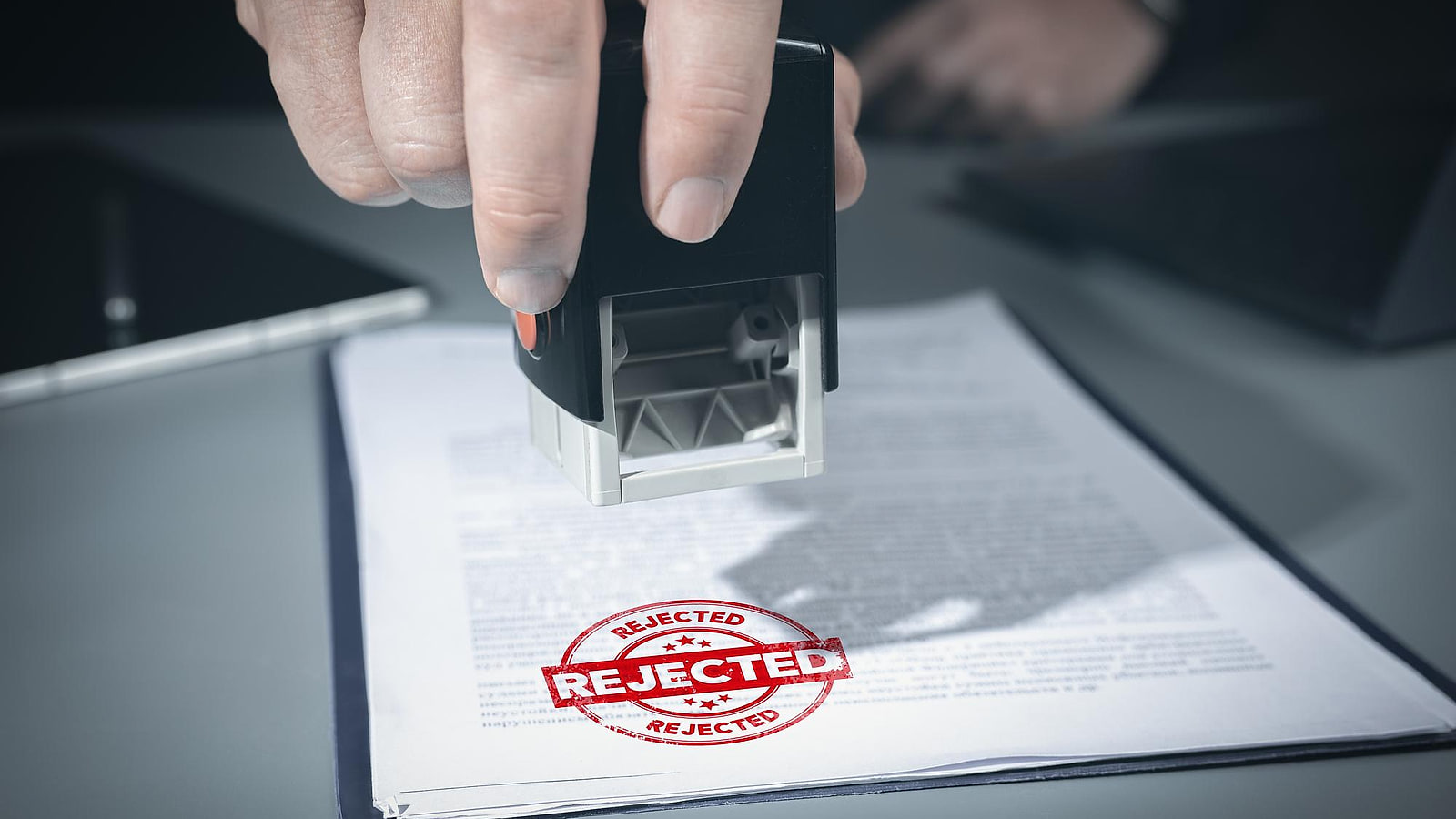 Responsable RH relisant une notification de refus de prise en charge OPCO devant un dossier de formation