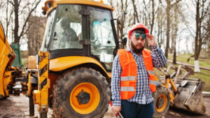 Conducteur formé au CACES R482 aux commandes d'un tractopelle sur un chantier