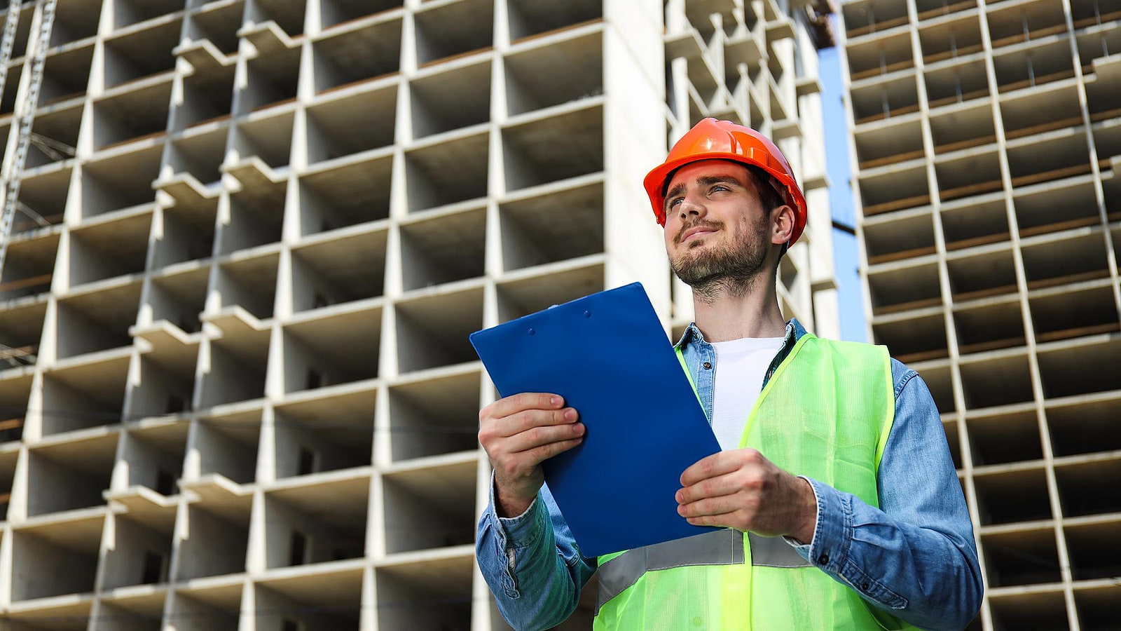 Chef de chantier annotant un plan d'exécution devant une tranchée de canalisation en cours de blindage