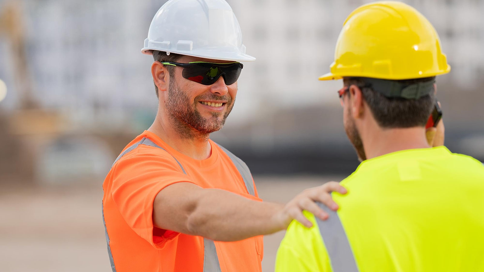 Conducteur tendant sa carte CACES au guichet de la base vie d'un chantier, casque et gilet fluorescent